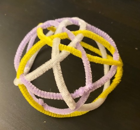 the pipe cleaners form a dome on the table, with a small pentagram on top